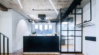 Entrance area of the practice Zähne im Zentrum in Münster. Open space with the clear lines of the reception desk and ceiling lighting.