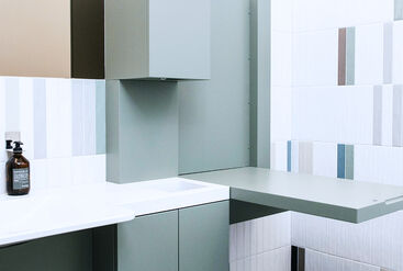 Bathroom with tiles in black, white and gray and minimalist design of the furniture in the dental practice Die Praxis Mitte in Berlin.